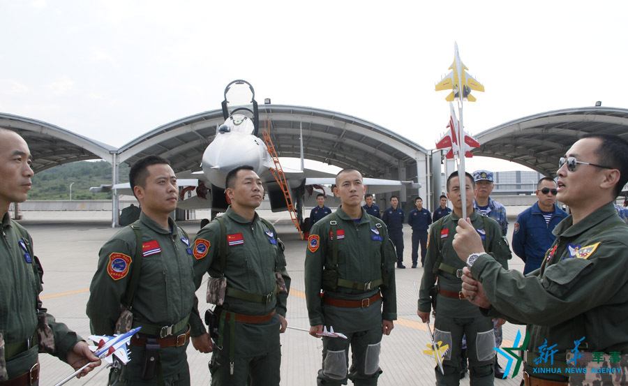 ↑海军某舰载航空兵部队部队长戴明盟带领飞行员进行地面模拟训练。